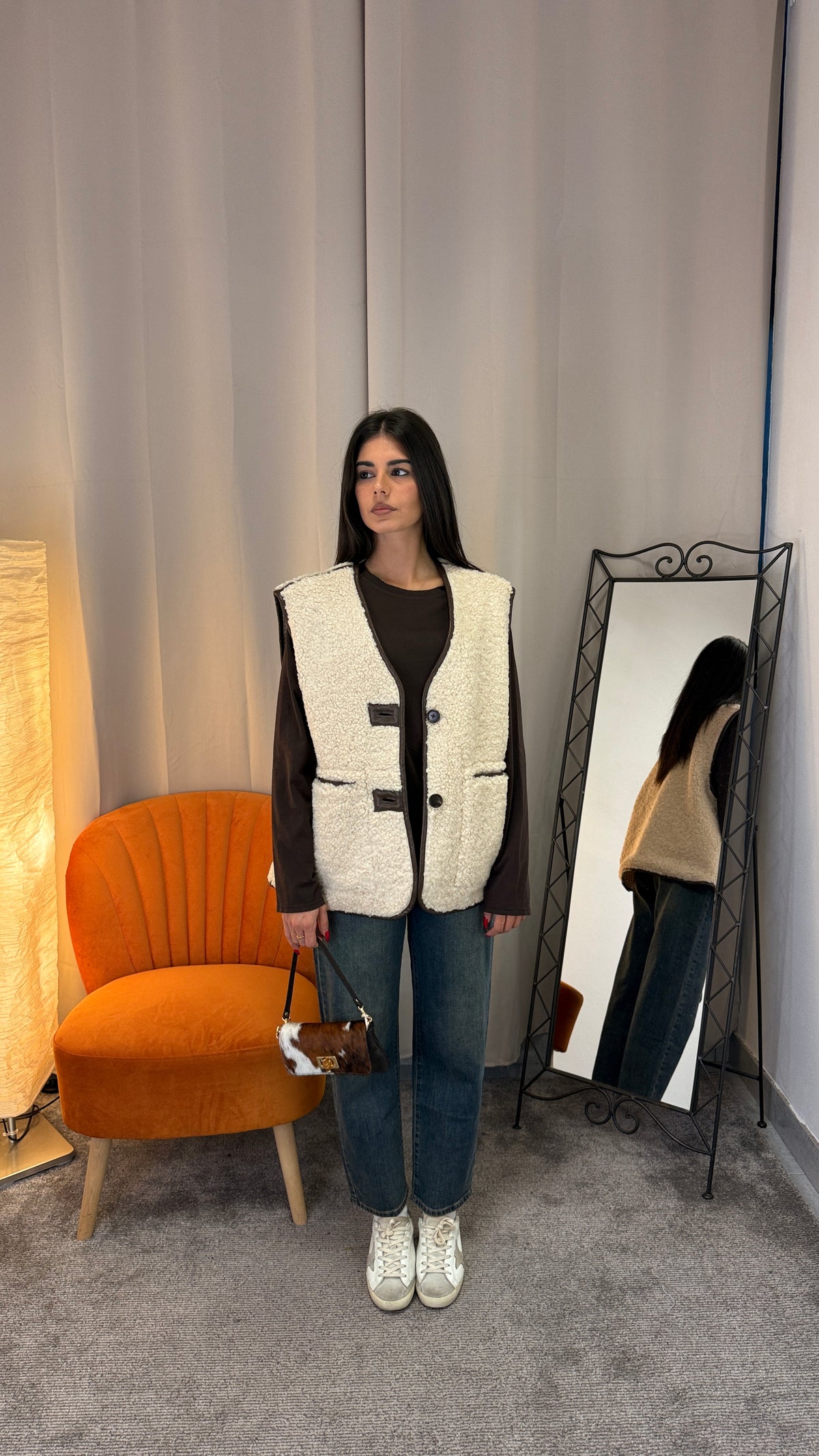 Gilet teddy oversize panna con inserti in ecopelle marrone indossato con jeans