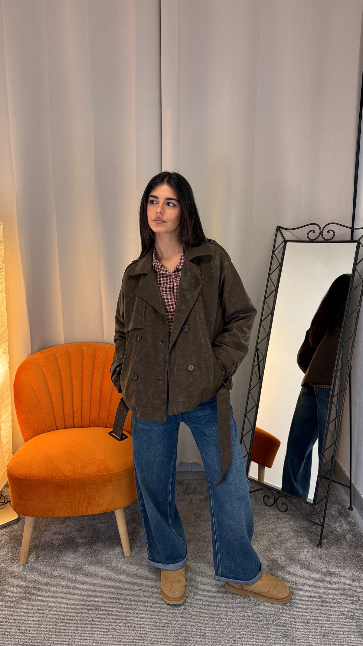 Trench corto in ecopelle marrone indossato con jeans